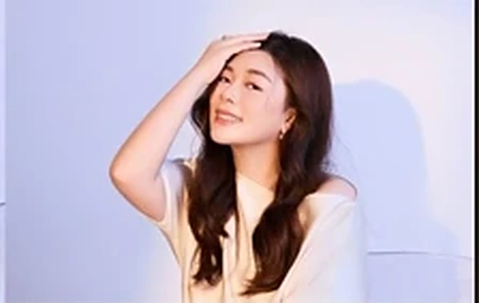 Eileen smiling, hand in her hair